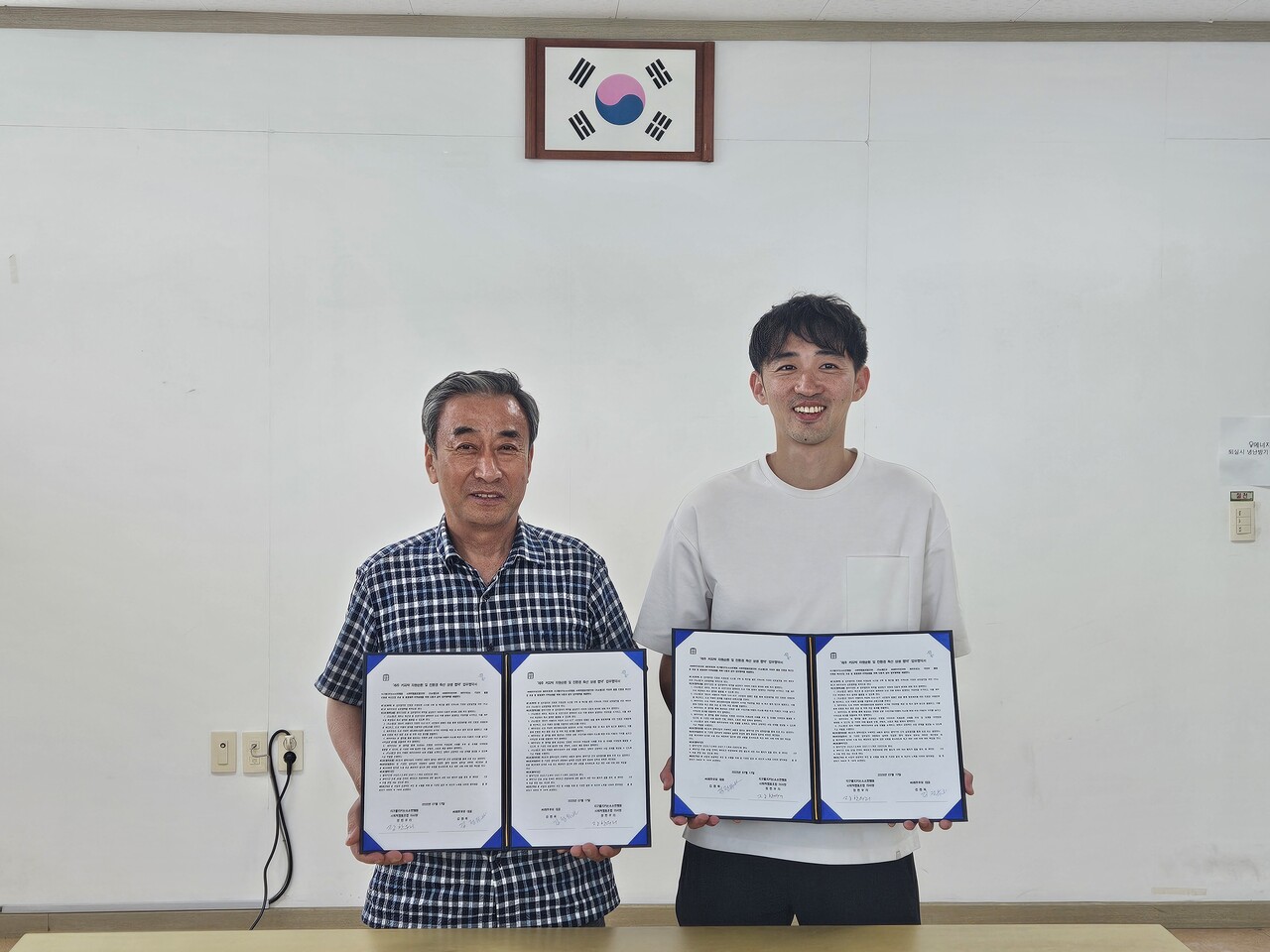 제주우유 김정옥 대표(왼쪽)와 지구를지키는소소한행동 장한우 이사장이 '제주 커피박 자원순환 및 친환경 축산 상생 업무협약'을 맺고 기념사진을 찍었다. /제공=지구를지키는소소한행동